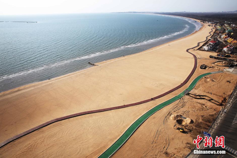 3月13日，秦皇島萬(wàn)米臨海沙灘木棧道。據(jù)了解，該木棧道全長(zhǎng)約4200米，與北戴河區(qū)原有的7500米木棧道對(duì)接后全線(xiàn)總長(zhǎng)度1.17萬(wàn)米，整個(gè)木棧道東起秦皇島體育基地游船碼頭，西至北戴河濕地公園，呈波浪形蜿蜒10.4公里海岸線(xiàn)。 中新社發(fā) 曹建雄 攝 CNSPHOTO